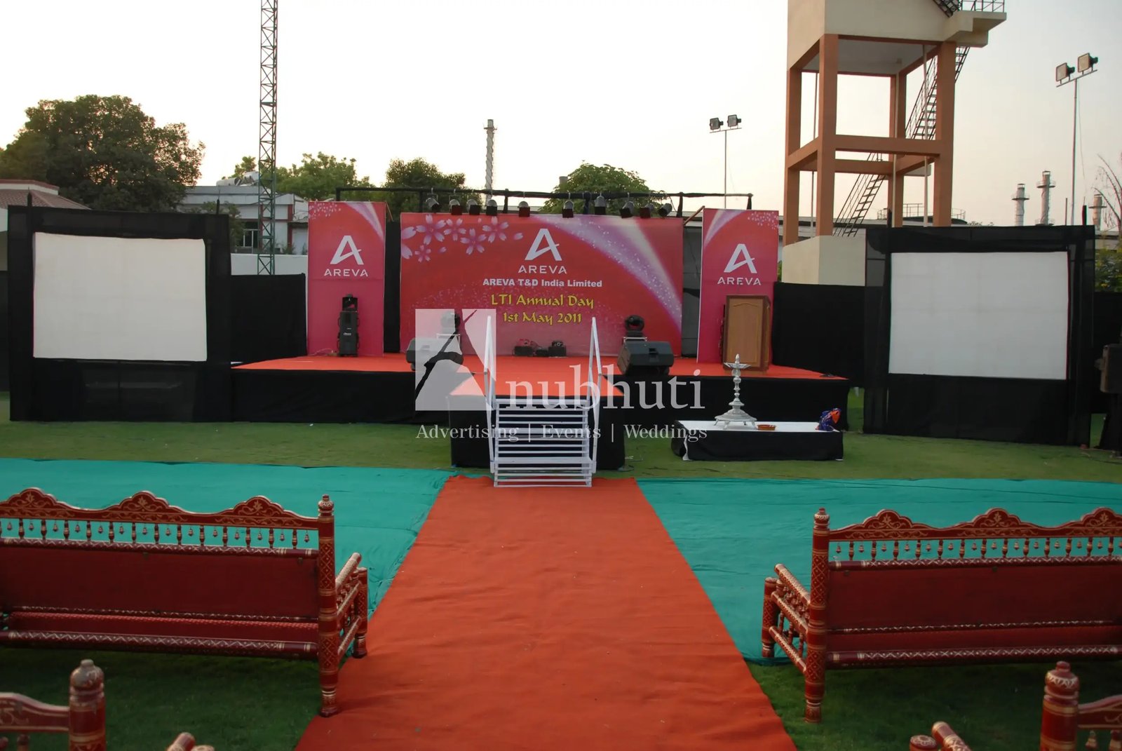 Men lighting ceremonial lamp at event with ITT banner in background